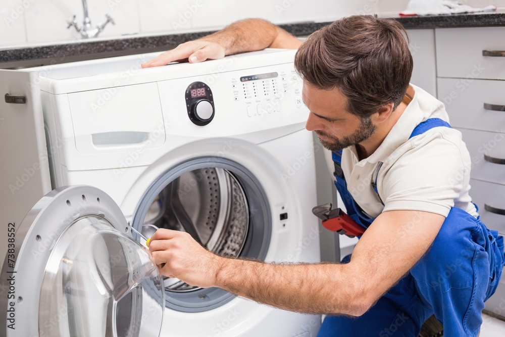 Handyman fixing a washing machine Handyman fixing a washing machine