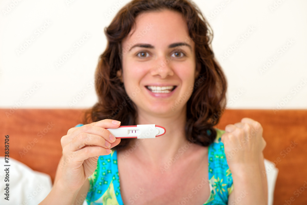 Happy woman with positive pregnancy test