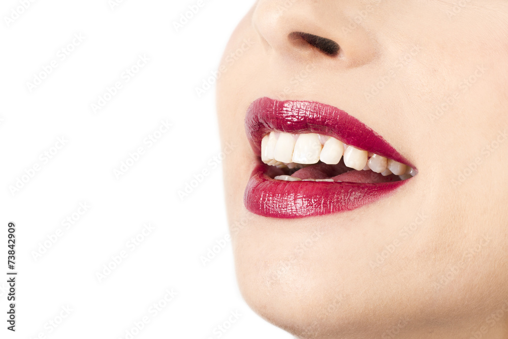 Obraz premium Rostro de mujer con labios pintados sonrisa en un fondo blanco aislado. Vista de frente y de cerca. Copy space