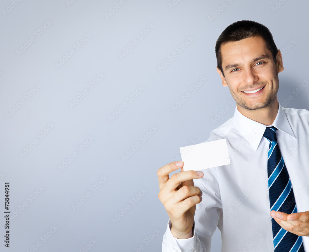 Businessman with business card, on grey Businessman with business card, on grey