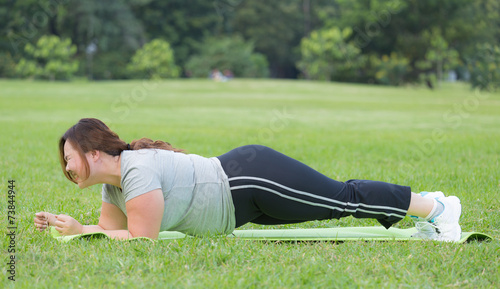 obese women planking on grass