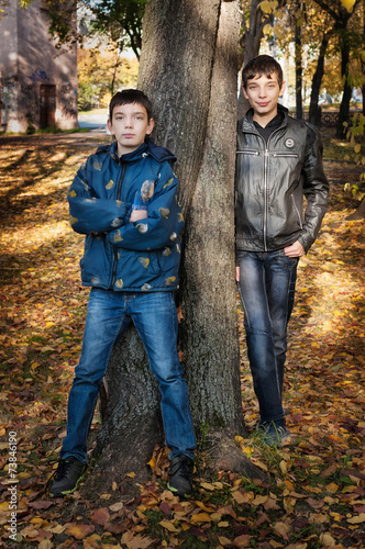 Two brothers standing near the tree