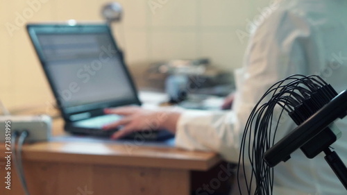 Woman having brain scan and doctor using laptop in hospital photo