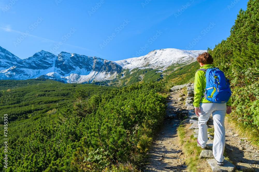 Woman tourist on hiking trail in Tatra Mountains, Poland