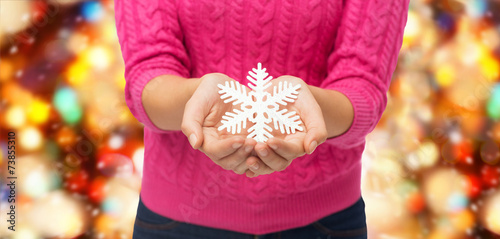 close up of woman holding snowflake decoration
