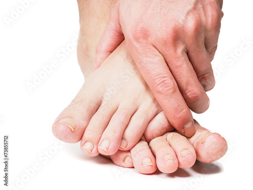 Tableau sur toile Male person holding onto feet isolated towards white