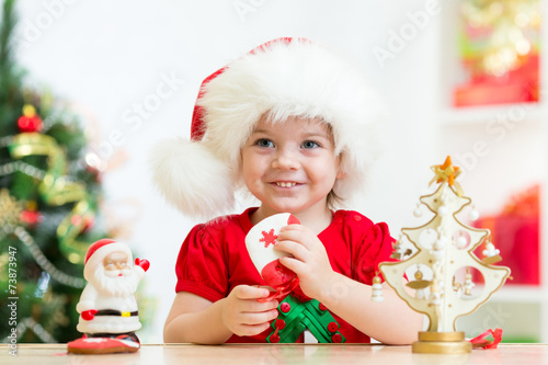 child girl in Santa hat hol...