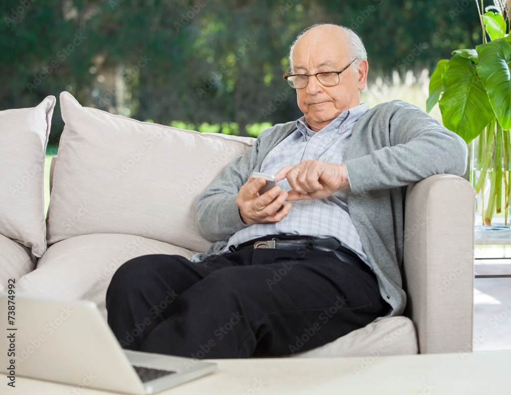 Senior Man Text Messaging Through Smartphone At Porch Senior Man Text Messaging Through Smartphone At Porch