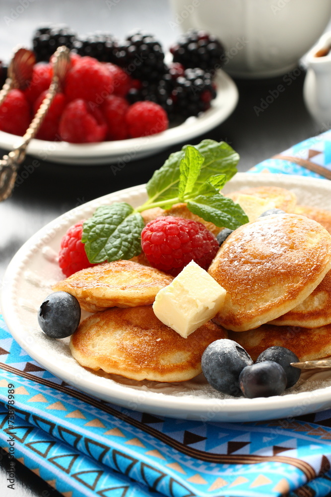 Dutch mini pancakes called poffertjes with berries