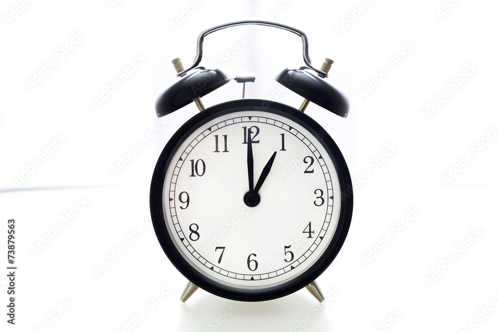 Oldfashioned black glossy alarm clock showing 1 o'clock Oldfashioned black glossy alarm clock showing 1 o'clock