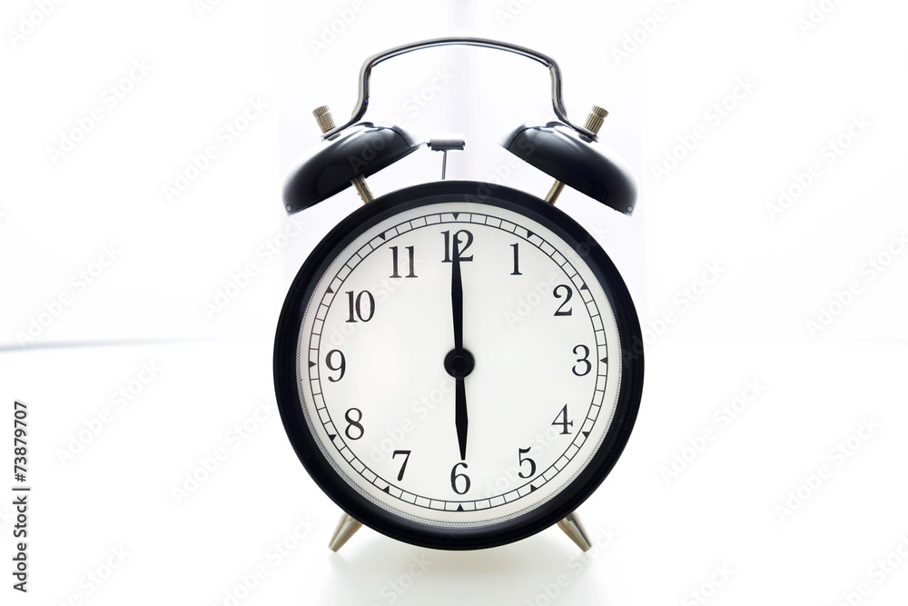 Oldfashioned black glossy alarm clock showing 6 o'clock Oldfashioned black glossy alarm clock showing 6 o'clock