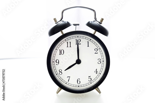 Oldfashioned black glossy alarm clock showing 8 o'clock