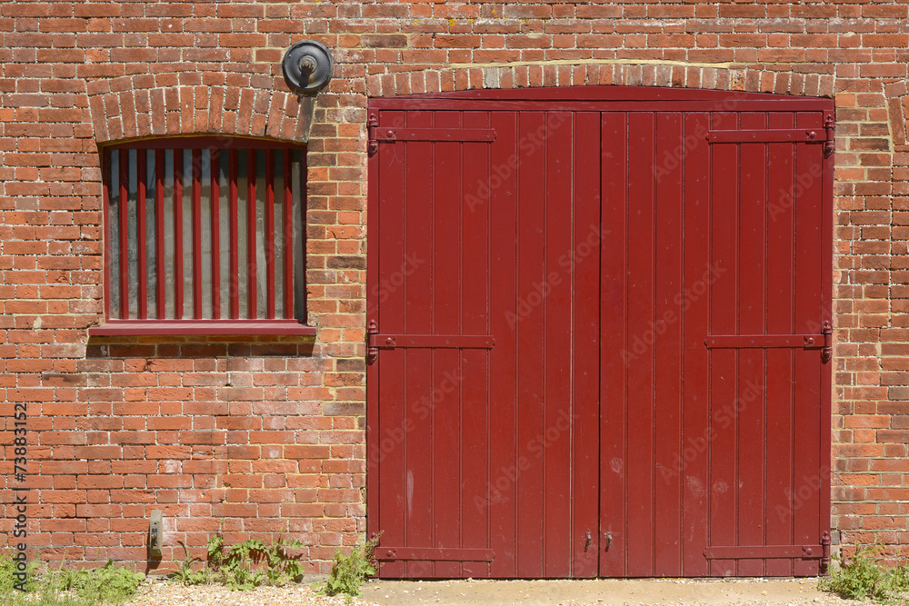 Red door and window in brick wall