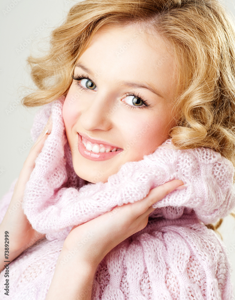 cheerful blond woman in a pink sweater. the winter season.