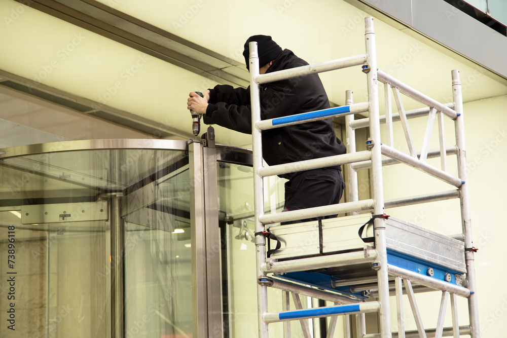 Naklejka premium handyman fixing a rotating door
