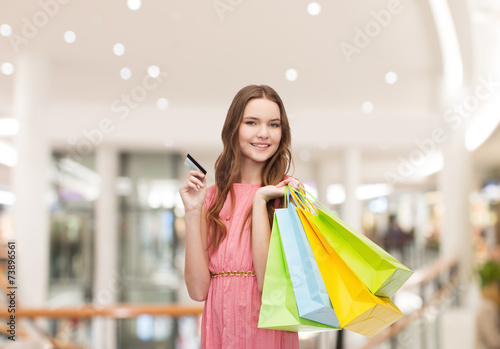 woman with shopping bags and credit card in mall