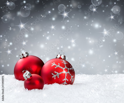 red baubles on snow with silver sparkle background
