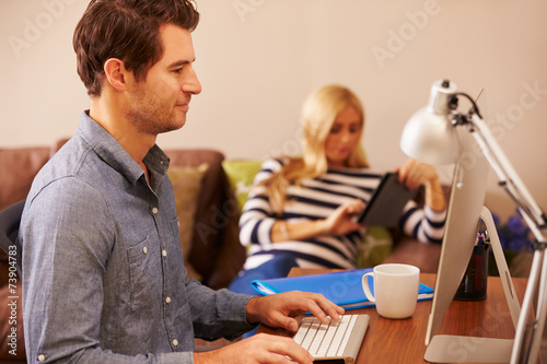 Man Sitting At Desk Working At Computer In Home Office