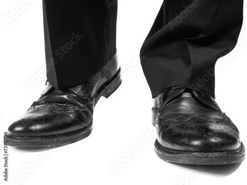 Masculine suit wearing black shoes approaching towards white