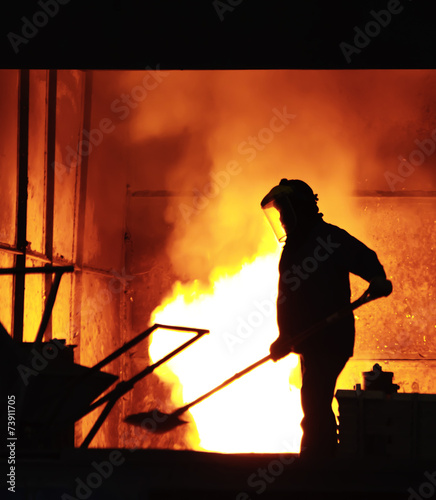 Man is working in the splashing molten iron - Stock Image