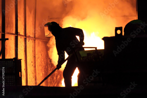 Man is working in the splashing molten iron - Stock Image photo