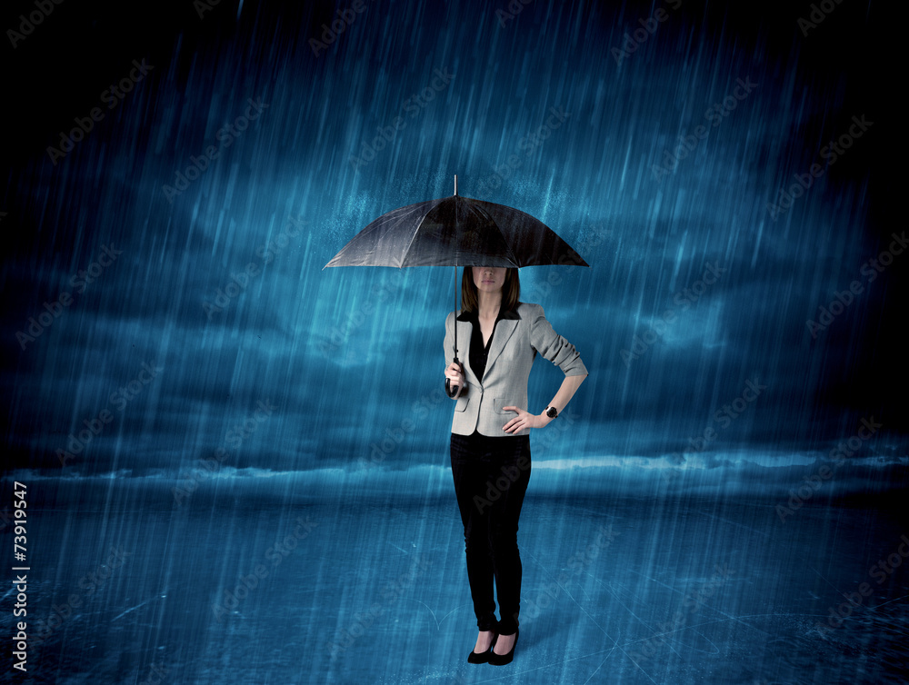 Business woman standing in rain with an umbrella