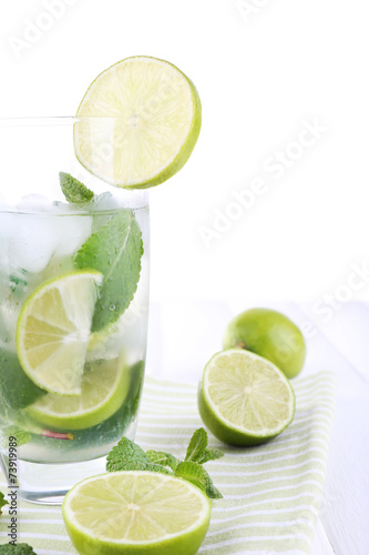 Lemonade in glass on napkin on bright background