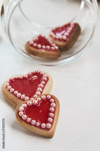 Red hearts cookies on white background and a bowl