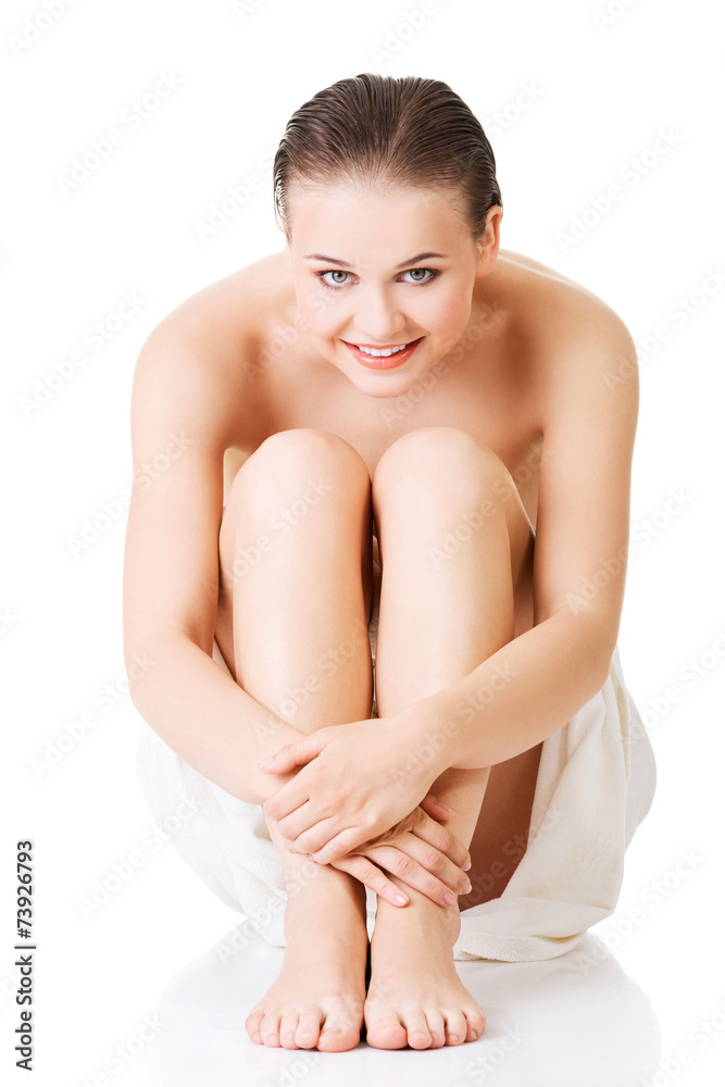 Front view of nude woman wrapped in towel sitting Front view of nude woman wrapped in towel sitting