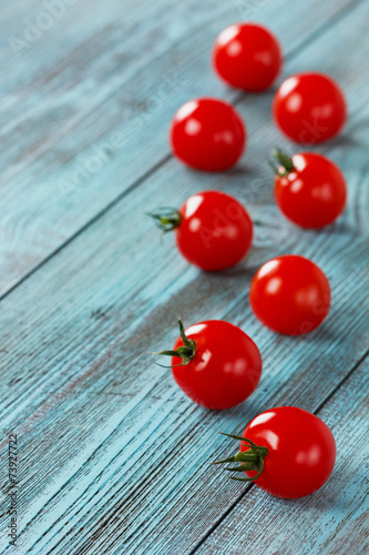 Cherry tomatoes on a turquoise colored wooden surface