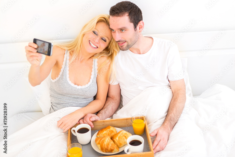 Young attractive couple taking selfie during breakfast