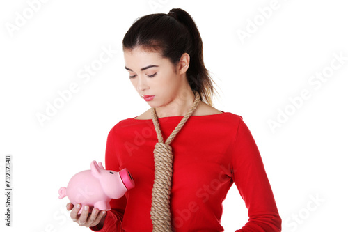 Sad woman with piggybank and rope around neck photo