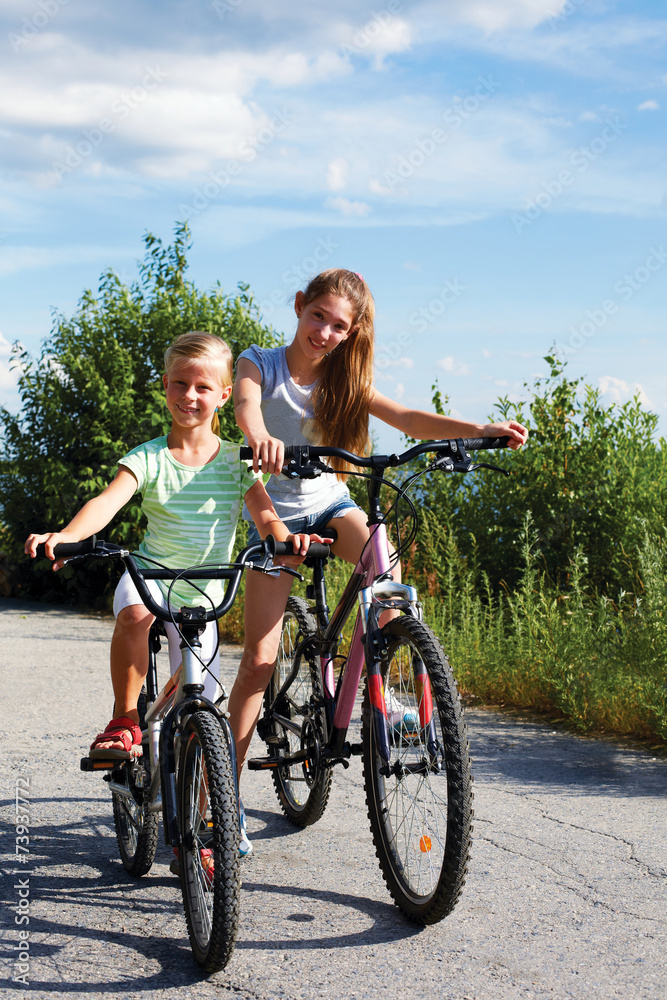 Two sisters On Cycle Ride In Countryside Two sisters On Cycle Ride In Countryside