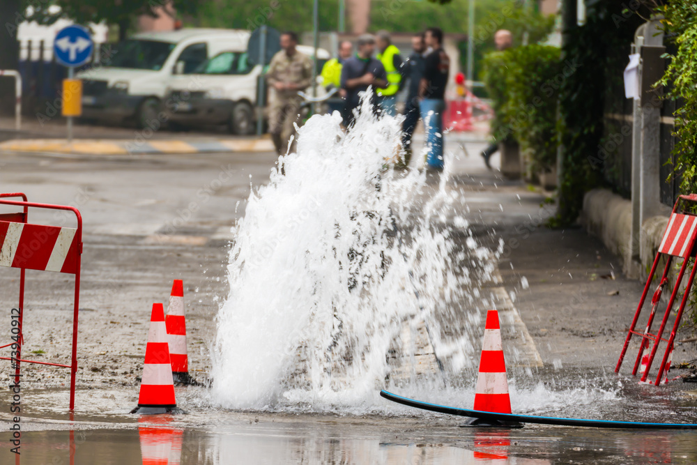 road spurt water beside traffic cones - obrazy, fototapety, plakaty 