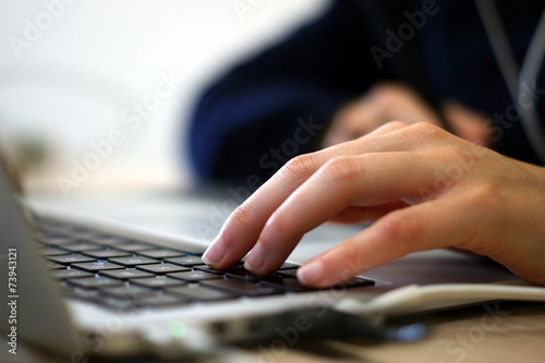 Close-up of the hands of an illustrator using a laptop