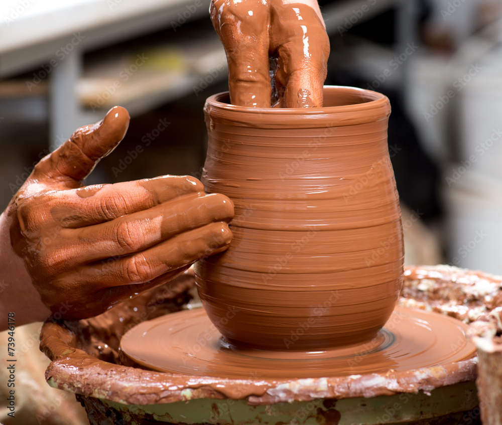 hands of a potter, creating an earthen jar