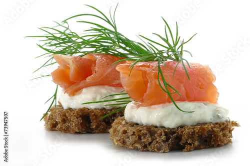 Fényképezés two  salmon canapes with fresh dill garnish, isolated on white b