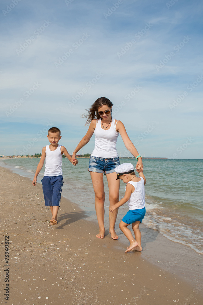 Mother and her two sons having fun on the beach