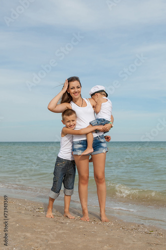 Mother and her two sons having fun on the beach
