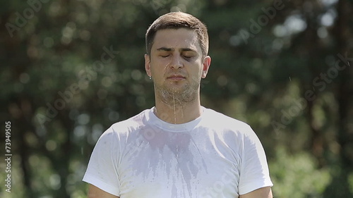 Beaten tired unshaven man pouring water slow motion
