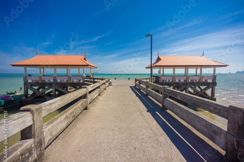 Long concrete pier on tropical beach with two canopy © Joshhh