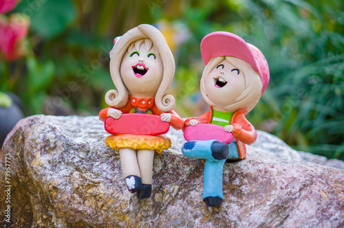 Two bright girls figures in garden