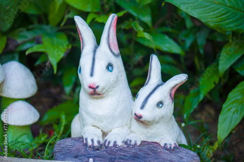 Two bright rabbits figures in garden