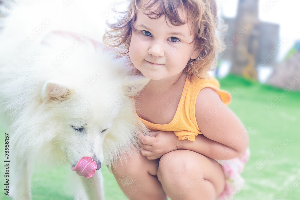 young child girl having fun with white dog on natural background young child girl having fun with white dog on natural background
