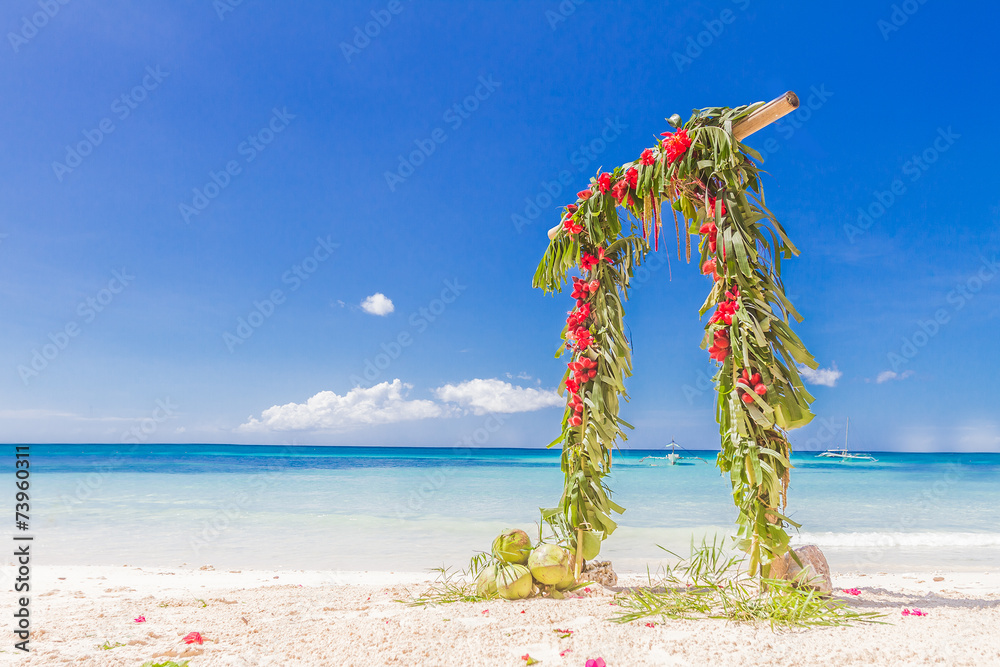 beautiful wedding arch decorated with palm trees and flowers on