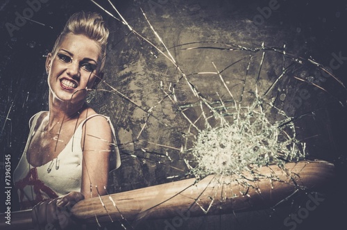 Foto Punk girl breaking glass with a baseball bat