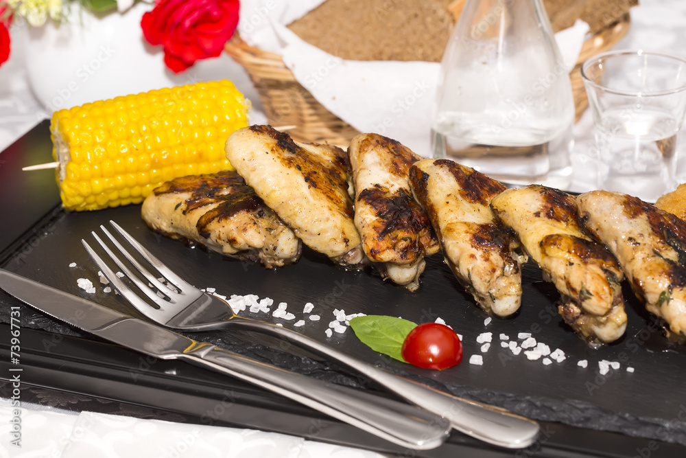 chicken wings are grilled on a wooden platter chicken wings are grilled on a wooden platter
