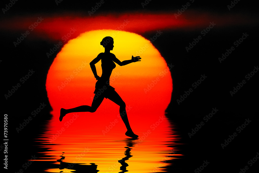 Woman jogging against a sunset ocean