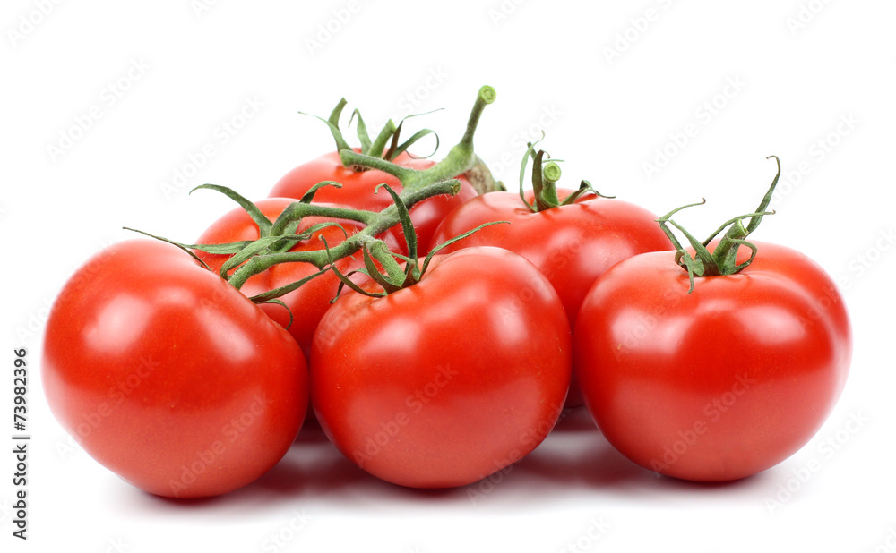 three fresh tomatoes with green leaves..