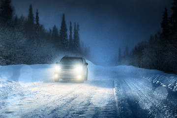 Car lights in winter forest